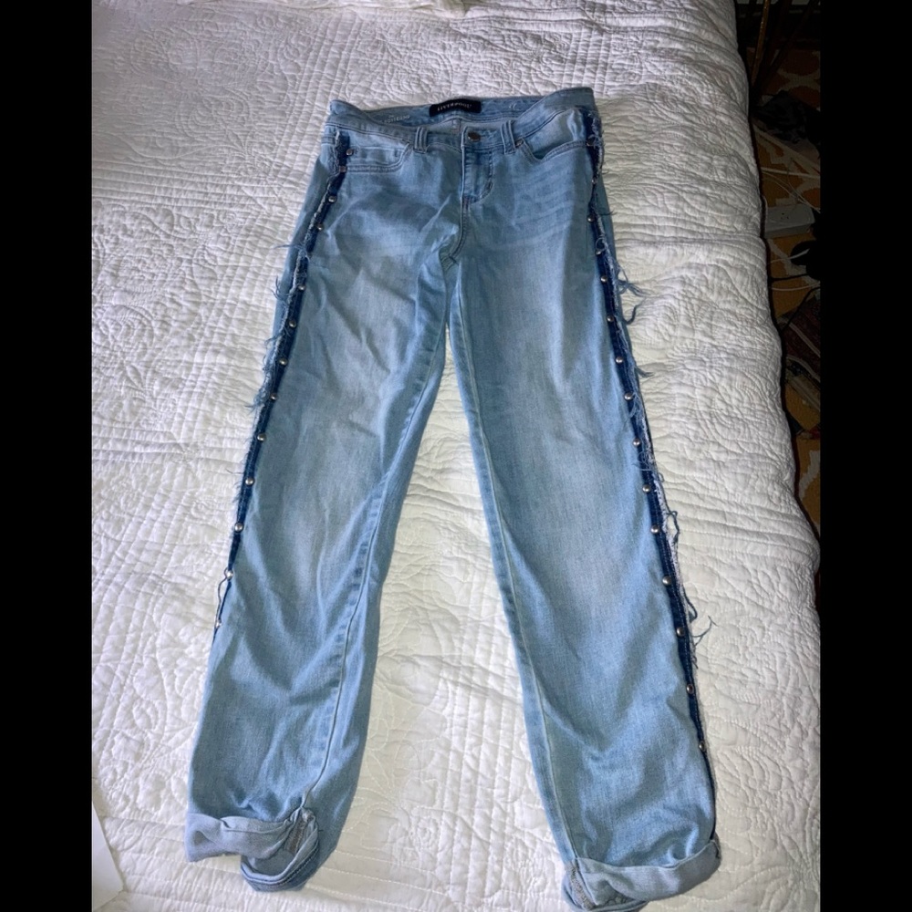 Lightwash boyfriend jeans with dark blue stripe and silver rivets on the sides.